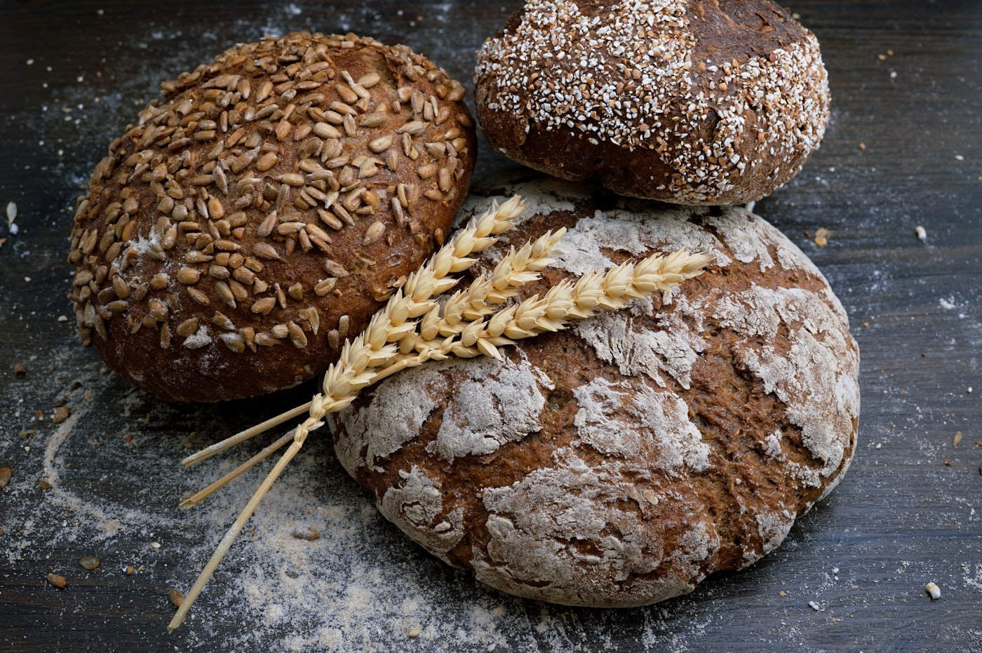 Rustic harvest loaves and wheat on a wooden table, cabin-kitchen baking mood